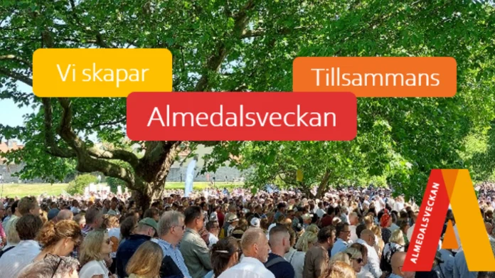 Stor folkmassa under träd på Almedalsveckan, med färgglada skyltar: "Vi skapar", "Tillsammans", "Almedalsveckan".