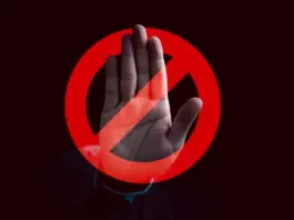 En uppsträckt hand bakom en röd stoppsymbol signalerar avvisande