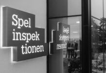 Skylt med texten Spelinspektionen utanför en byggnad, speglas i fönsterglas med personer synliga inomhus.
