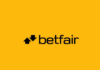 Betfairs logotyp med svart text och två pilar på gul bakgrund.