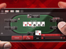Två händer håller en mobil med ett pokerbord på skärmen och flera spelare runt bordet.