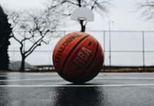 an nba basketball laying on a blacktop surface