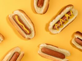 A series of hot dogs displayed on a yellow background