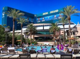 Guests relax at the MGM Grand Las Vegas pool with the hotel and monorail in the background on a sunny day.
