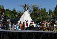 Native American tribal members in traditional regalia at a cultural event.