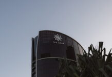 The Star Entertainment building in Australia, with logo visible on curved glass facade under a clear sky.